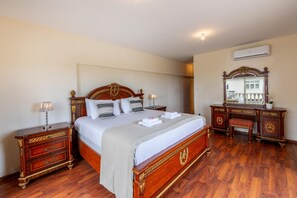 A bedroom with a wooden bed, nightstands, a dresser, and a mirror. - Protaras Posidon By The Sea (Paralimni)