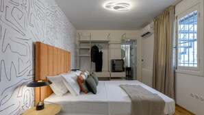 A modern bedroom with a bed, bedside table, and a wardrobe. - Paradise Suite With Jacuzzi Acropolis View (Athens)