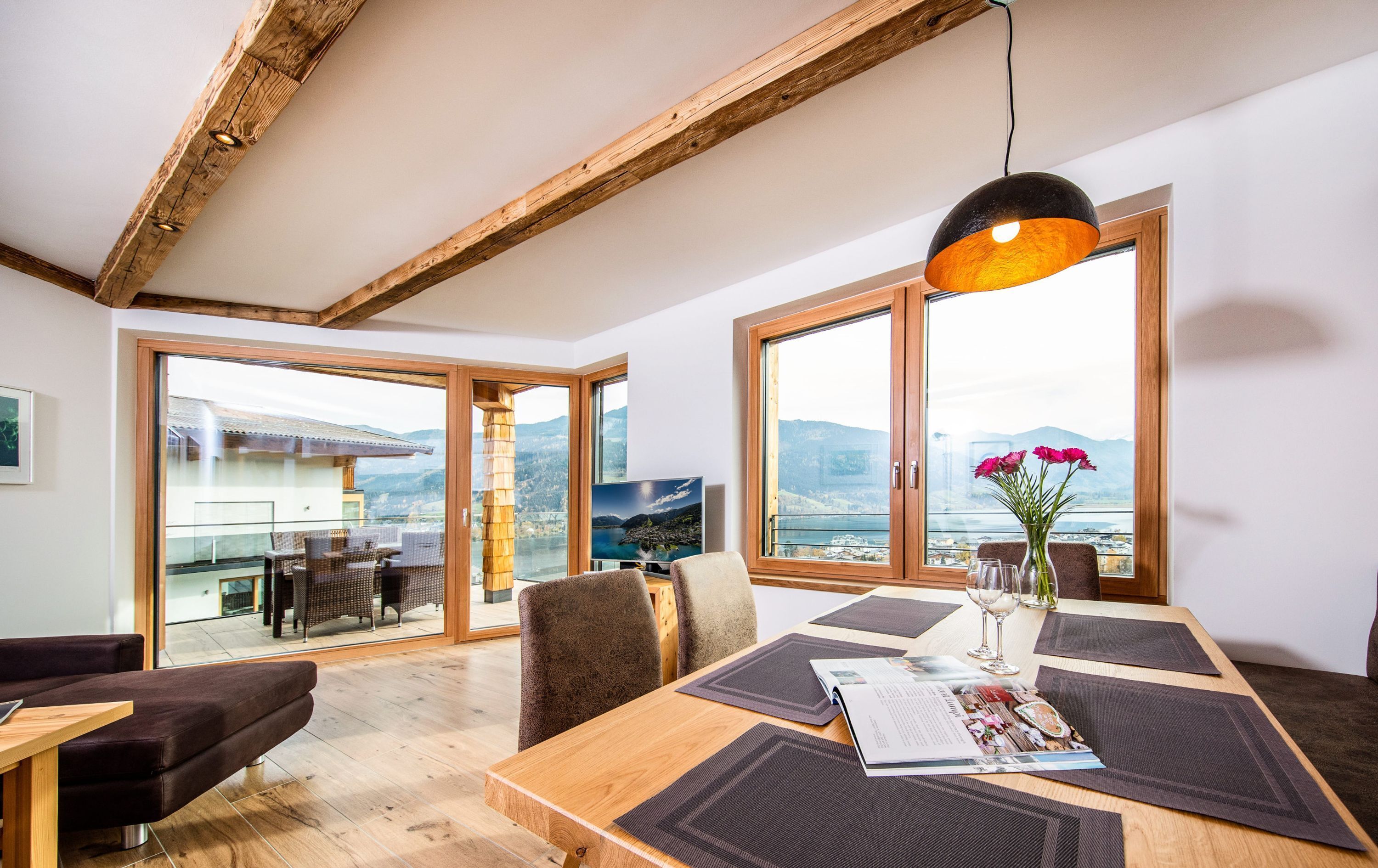 Un comedor amplio con una mesa de madera, sillas y un ventanal que ofrece una vista panorámica.