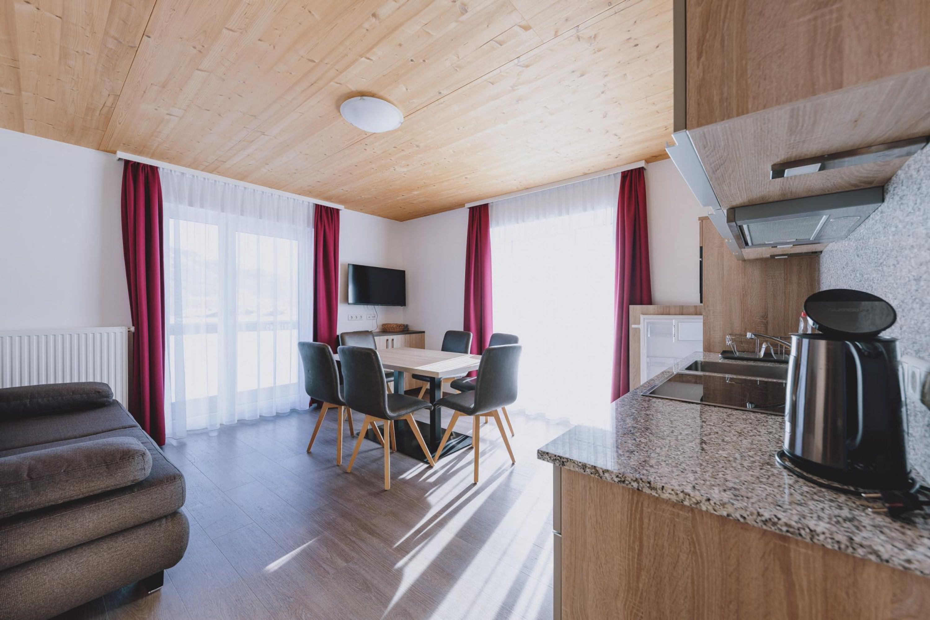 A modern kitchen with a granite countertop, a coffee maker, and a built-in oven.