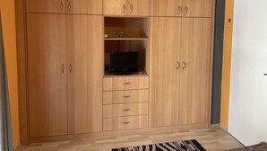 Un armario de madera con repisas para la televisión y cajones.