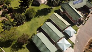 A residential area with multiple houses, each with a green roof and a small garden. - Twin Room in Hillside - 2087 (Bulawayo)