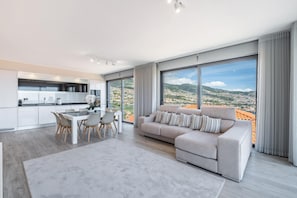 Relax in a spacious living area with a plush sofa and floor-to-ceiling windows offering a panoramic view.