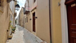 A narrow street with buildings on either side, a wooden door with the number 31, and a small balcony with a wrought iron railing. - Katrina Studio 3 With Balcony (Rethymno)