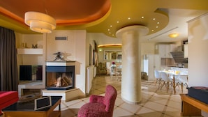 Una sala de estar amplia con chimenea, un comedor y una cocina.