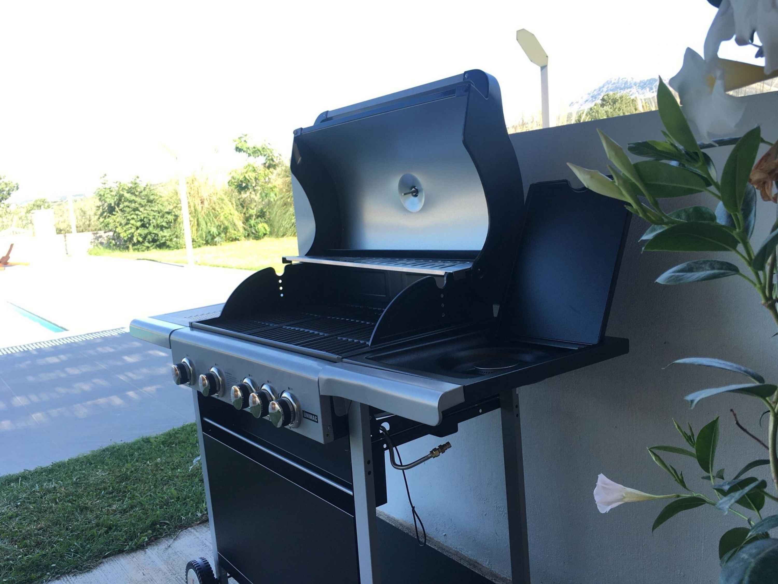 Ein tragbarer Gasgrill mit Bedienfeld und Wassertank.