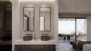 Un baño moderno con dos lavabos, un espejo grande y un banco empotrado.