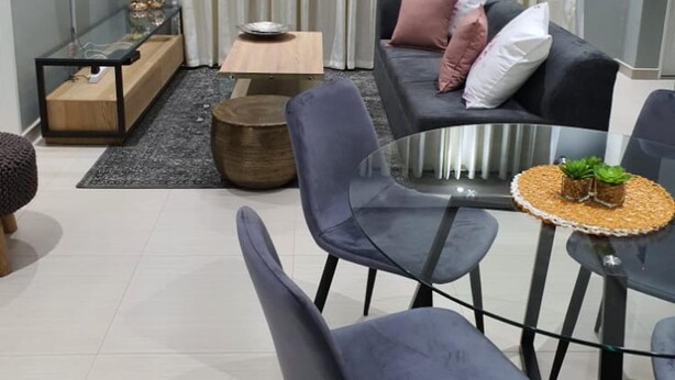 A modern living room with a sofa, chairs, a coffee table, and a TV mounted on the wall. - Posh 3 Bed Guesthouse in Hillside With Pool - 2039 (Bulawayo)