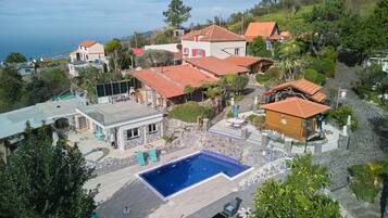 Un barrio residencial con piscina, senderos de piedra y casas con tejados rojos.
