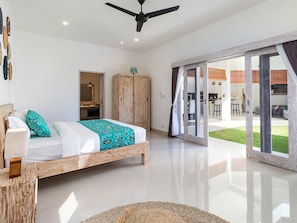 Relax in a spacious room with a large bed, wardrobe, and sliding door leading to a balcony with an outdoor view.