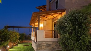 A modern house with a covered porch, stone foundation, and a swing set in the yard. - Villa David With Private Pool (Malevizi)