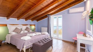 A bedroom with a bed, a bench, a desk, and a window with a view. - Olive Tree Villa by Estia (Corfu)