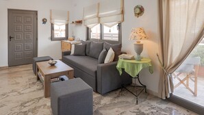 A living room with a grey sofa, a small table, and a lamp. - Yialos Cohili Beach Residence by Estia (Hersonissos)