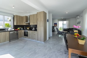 Enjoy a spacious living space with a kitchen, dining area, and large windows offering a view of the outdoors.