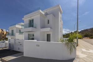Relax in a clean, minimalist space with a covered outdoor area and a view of the natural surroundings.