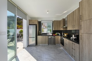 Enjoy cooking in this well-lit kitchen with a stainless steel refrigerator, cabinetry, and dishwasher.