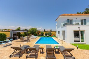 A modern house with a swimming pool, outdoor seating, and a view of the countryside. - Ayia Napa Marina Vibes (Sotira)