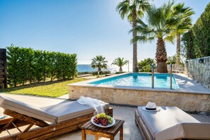A poolside area with lounge chairs, a small table with a plate of grapes, and a view of the sea. - Palmrise Luxury Villas - Maistros Villa (Kassandra)