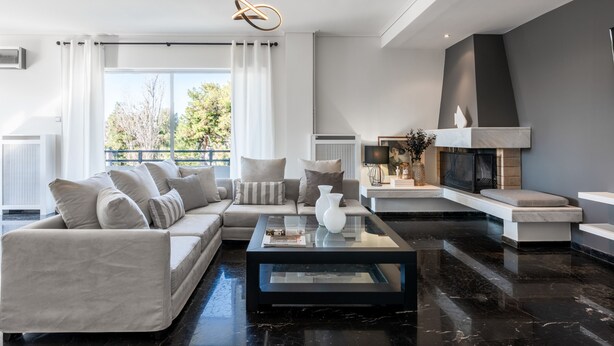Una sala moderna con sofá, mesa de centro y chimenea.