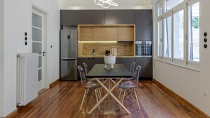 A modern kitchen with a central island, wooden cabinets, and a large window. - 3bdr Modern Design Bright Interiors in Plaka (Athens)