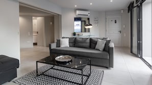 Una sala de estar moderna con un sofá gris, una mesa de centro y un tapete estampado.