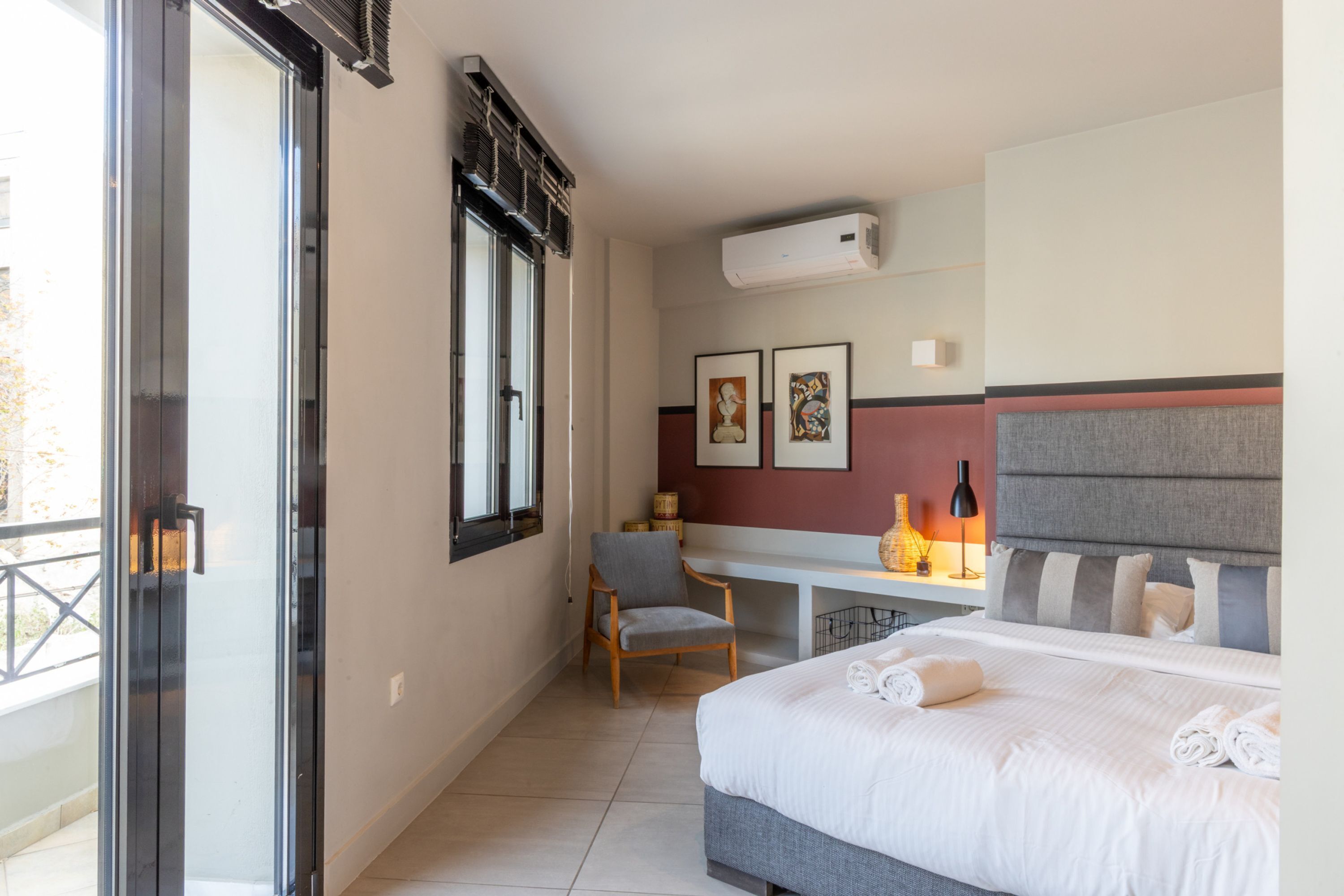 Una habitación de hotel con cama, escritorio, silla y ventana.