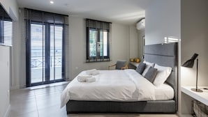 Un dormitorio moderno con una cama grande, una silla y un escritorio.