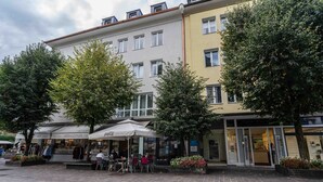 A courtyard with outdoor seating, a flower shop, and a building with multiple windows and balconies. - Living Eden - TOP 3 in Zell am See (Zell am See)
