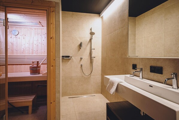 Une salle de bain moderne avec un sauna en bois, une douche à l’italienne et un grand miroir.