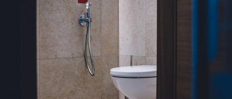 Une salle de bain avec une douche, des toilettes et un panneau sur le mur.