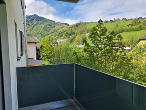 A balcony with a view of a green valley and houses. - FP Appartements - Penthouse (Kaprun)