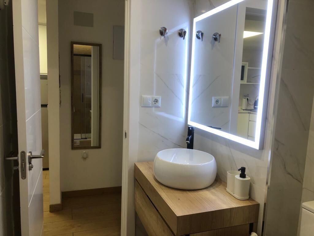 Ein Badezimmer mit Waschbecken, Spiegel und Holzschrank.