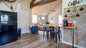 A kitchen with a black refrigerator, wooden flooring, and a coffee-themed wall. - Walk to Lake Erie — Renovated 2BR Huron Home Near Cedar Point & Kalahari (Huron)