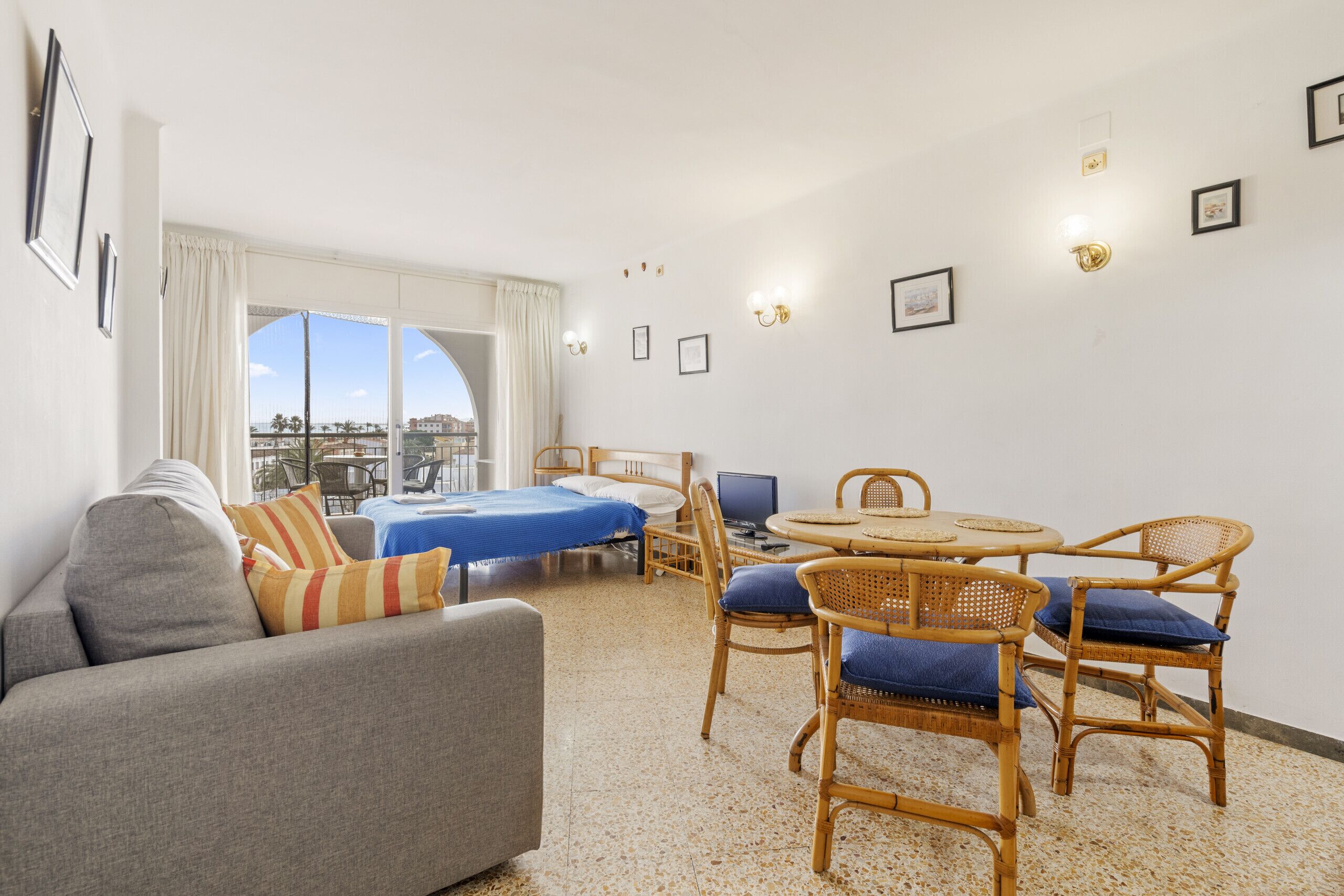 Une chambre d’hôtel comprenant un lit, un canapé, une table à manger avec des chaises et une vue sur la ville.