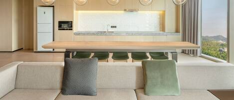A modern kitchen with a wooden countertop, a built-in oven, and a large window offering a city view.