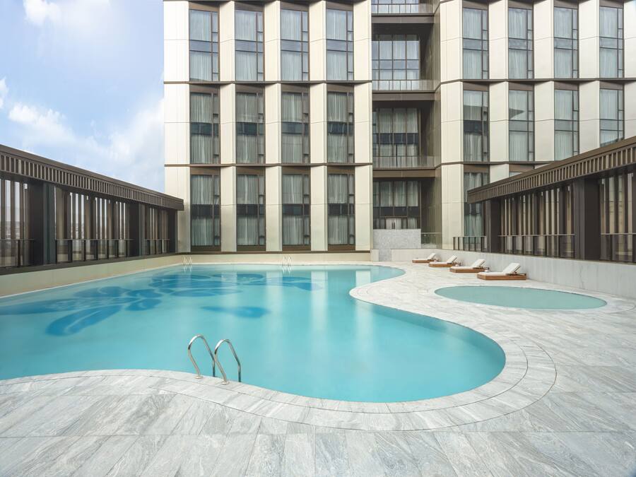 Una piscina al aire libre de temporada, sombrillas