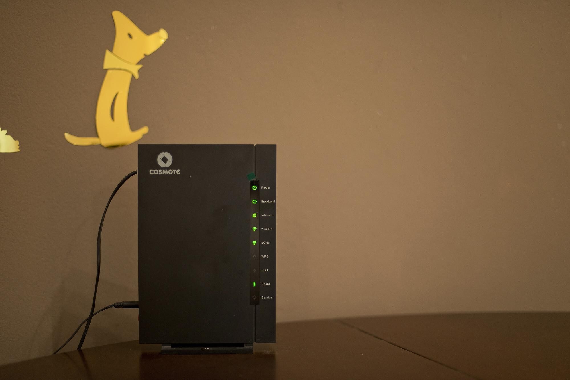 Il s’agit d’un appareil noir sur lequel figure, en haut, le logo « COSMOTE ». Il est doté d’un bouton d’alimentation, d’un bouton pour la connexion haut débit, d’un bouton pour la connexion Internet, d’un bouton 5 GHz, d’un bouton 2,4 GHz, d’un bouton pour la configuration sécurisée Wi-Fi (WPS), d’un bouton USB, d’un bouton téléphone et d’un bouton service.