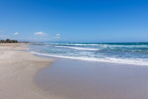 A beach with a clear sky, calm sea, and a sandy shore. - Yialos Ammos Beach Residence by Estia (Hersonissos)