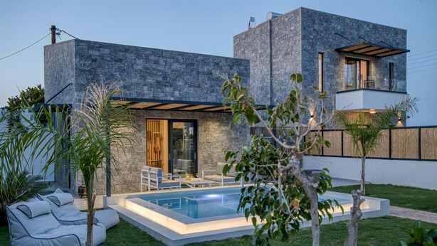 Una casa moderna con piscina, patio coperto e prato curato.