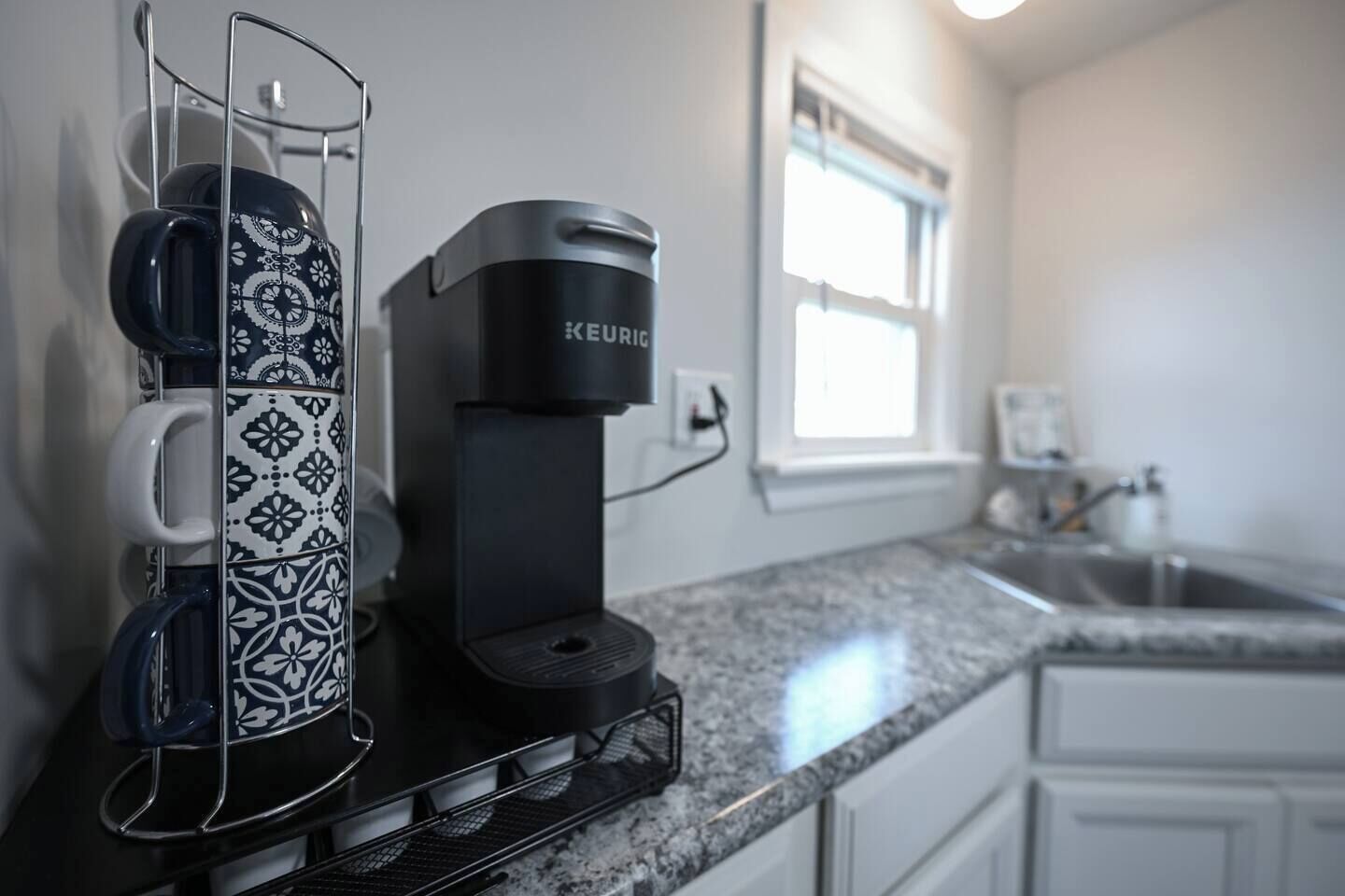 Une cuisine équipée d’une machine à café, d’un porte-tasse et d’un évier.