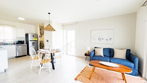 Un appartement moderne comprenant une cuisine, un coin repas et un salon.