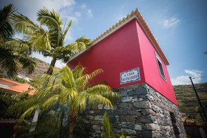 Un bâtiment rouge avec une base en pierre et une enseigne sur laquelle on peut lire : « A CASA DO PALHEIRO ».