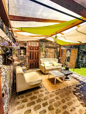 Relax in a serene outdoor seating area with a sofa, armchair, and small table.