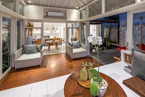 Relax in this stylish living area with a sofa, armchairs, and a coffee table, surrounded by a modern open-plan layout.