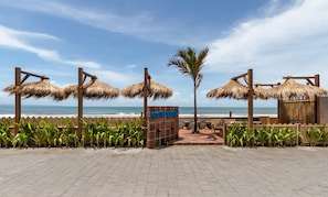 Relax under the shade of thatched umbrellas in this beachfront area, surrounded by lush greenery and the soothing ocean views.