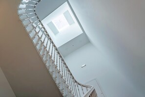 Una escalera de caracol con diseño moderno, tragaluz e interior minimalista.