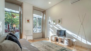 Una sala de estar moderna con sofá, televisor y obra de arte en la pared.