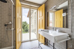 Ein Badezimmer mit Dusche, Waschbecken und einem großen Fenster.