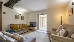 Olohuone, jossa on sohva, televisio ja kynttelikkö.