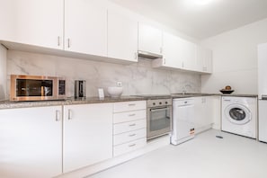 Enjoy cooking in this well-equipped kitchen with oven, dishwasher, and washing machine.
